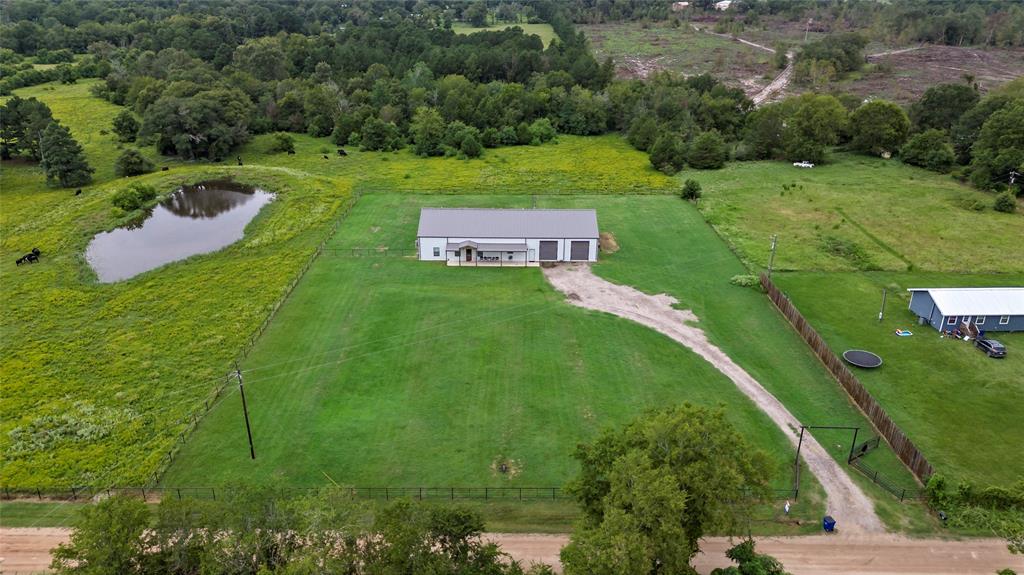 This well maintained, one owner barndominium was custom built for space, functionality and entertaining. With gorgeous views of greenery out every window and a front porch that spreads the width of the house, it is sure to give you peace and quiet! Upon entry you will find a large family room that opens up into a large dining room and kitchen with loads of cabinet storage. Right off the kitchen you will find a massive utility room equipped with a half bathroom and more storage. The primary suite offers a large bathroom with two large closets areas. Off the living room you will find 3 additional bedrooms all with large closets. Between the middle bedroom there is a Jack and Jill bathroom and at the end of the main hallway you will find another separate spacious bathroom. There is a close to 40X50 shop attached to the house with three large rolling doors that open up through the space for vehicles, lawn equipment or gatherings. Four miles to Lovelady! You don't want to miss this one!!