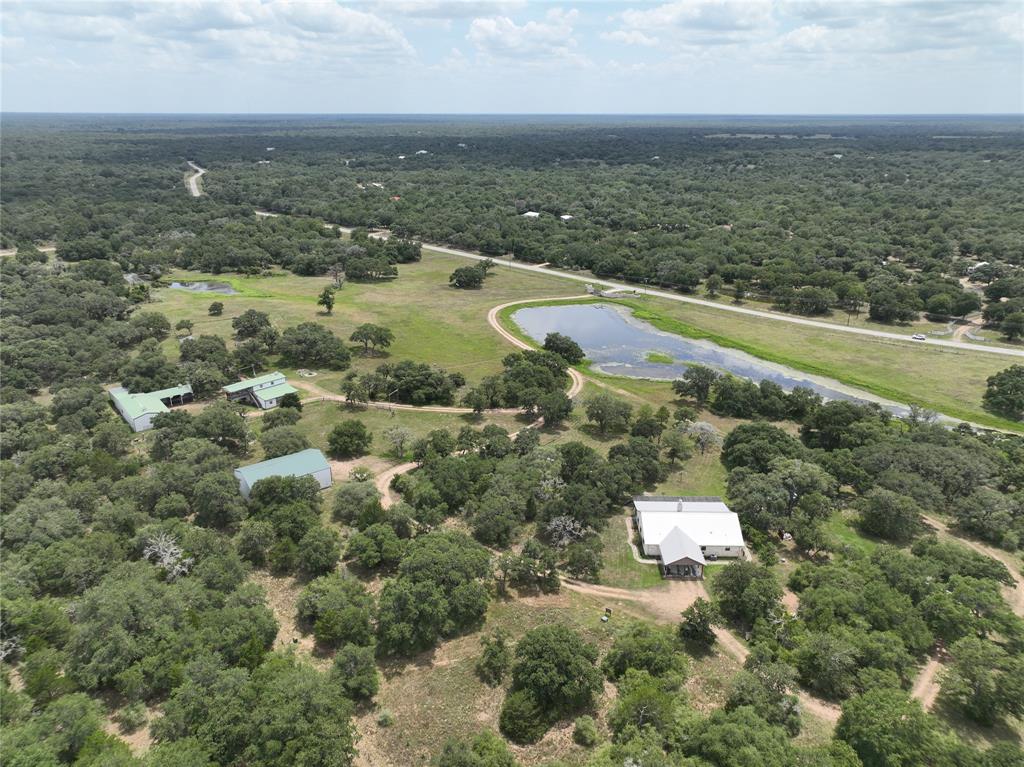 Beautiful ranch featuring multiple living areas. The main hm, built in 2015, consists of 2BR/2.5BA, a metal roof, fireplaces, lg kitchen 2/ custom cabinetry, marble countertops & stainless-steel appliances. This open concept hm offers both comfort and style. The lg front porch extends the length of the hm & offers beautiful views of the in-ground pool & tranquil countryside. In addition, there are 3 lg metal buildings on the property. The 1st bldg. offers 2 APARTMENTS, ea. w/ a BR, BA & kitchen. The upstairs offers a lg deck which is ideal for enjoying the vast amt of wildlife that frequents the area. The 2nd is a 40X60'w/roll up doors equipped to house 2 RVs or numerous vehicles. The 3rd has 3 lg bays w/ roll-up doors & a spacious climate-controlled workshop. Oakridge Ranch is located between Weimar and Columbus, making shopping & outside entertainment convenient. To learn more of what Oakariiiidge Ranch has to offer, visit their website at oakridge-ranch.ocom.