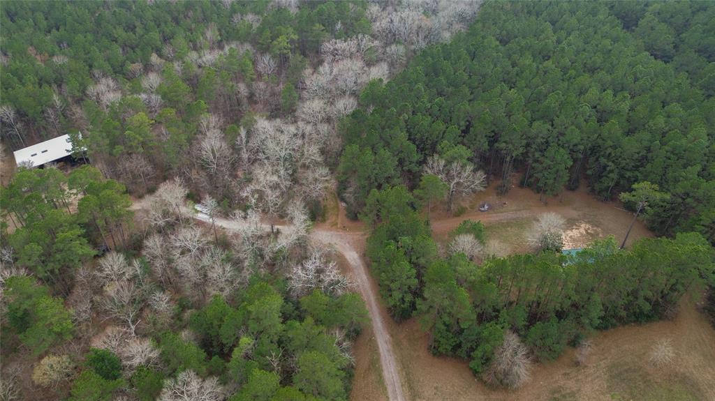 55+/- acres of timber and trails have been thoughtfully curated with wildlife at the forefront. A wet weather creek, pond, improved grasses, and feeders provide an oasis for deer, ducks, squirrels, and countless birds.. A 45’x65’ three-sided shop has been constructed with commercial-grade materials. You will find a 12’x25’ insulated bunk room with a bathroom, rain catch water system, and solar powered lights and plugs. For those not wanting to utilize these off-grid resources, water, power, and fiber optic are at the county-maintained road. The main shop area has a sink, ample storage space, and room for tractors, side by sides, trailers, and equipment. The pasture to the west has a 14’x40’ concrete pad that is ready for a cabin to be built. With hunting in mind, feeders and stands are in place and will convey with the property. The 12’ pond was revamped in 2019, with plenty of black gumbo used for maximum water retention. Enjoy the wildlife exemption that is already in place.