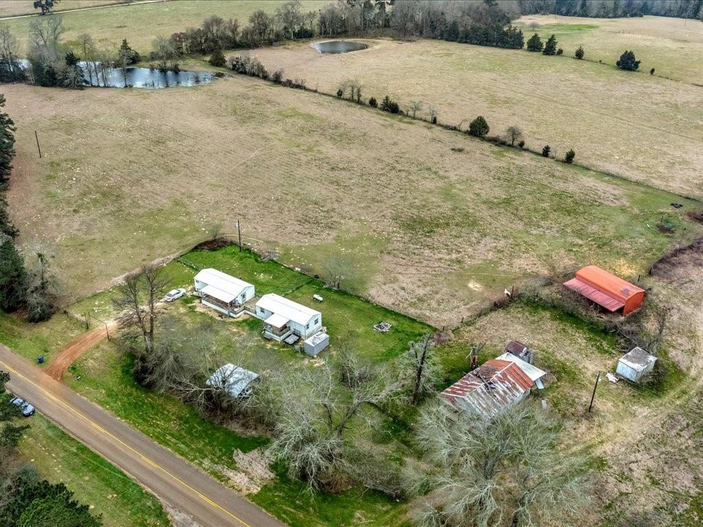 Discover country living at 4229 FM 3016 in Grapeland, Texas. Nestled on 12.70 acres of fenced and cross-fenced land, this unique property is ready for your horses and offers two separate one-bedroom, one-bathroom homes, seamlessly connected by wraparound porches that provide stunning views of the surrounding countryside. Each home features its own laundry room, a tankless hot water heater, and comfortable living spaces designed for both relaxation and functionality. The gated driveway ensures privacy and security, while the carport offers convenient covered parking. With low taxes and no HOA, you can truly enjoy the freedom of country living. Whether you’re looking for a multi-generational living setup, a guest retreat, or a peaceful rural escape, this property provides endless possibilities. Bring the horses and experience the best of Texas country living—schedule your showing today