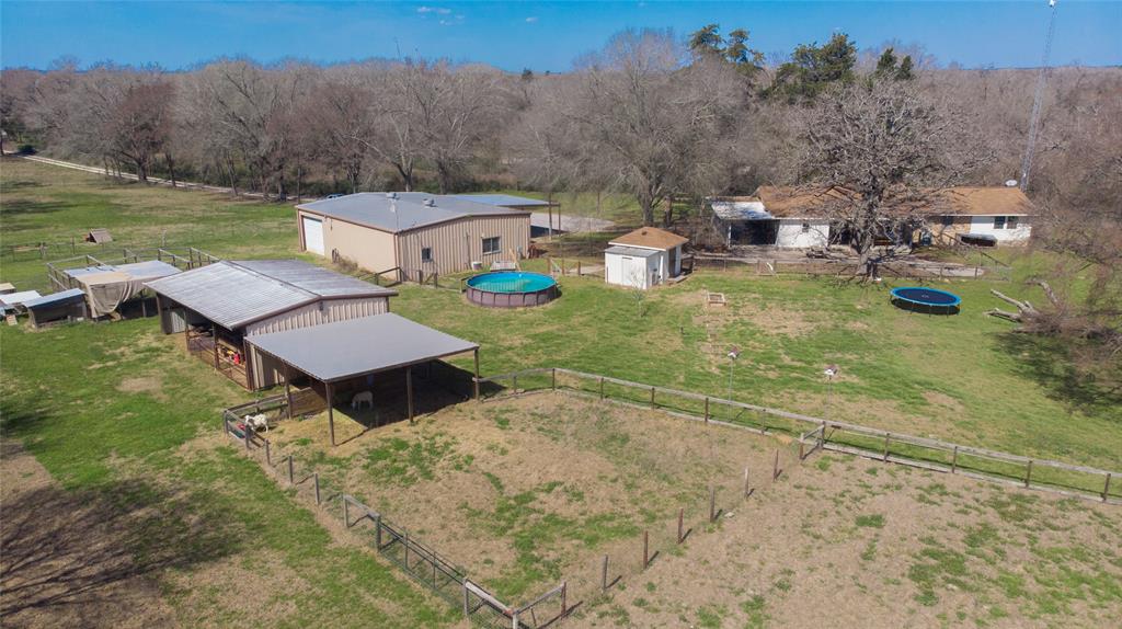 Discover the perfect blend of comfort and functionality on 6 acres just outside of Bryan/College Station! This home features 4 bedrooms, 2 full baths, and an open kitchen featuring granite countertops, dining, and living area with a wood burning fireplace. Whether you want to raise animals, garden, or enjoy country living, this property has it all! The 50x40 shop includes 2 roll-up doors and a 3 car carport for ample parking and storage. Inside the shop, a 1-bed, 1-bath apartment with a full kitchen including a washer and dryer offers space for guests OR rental income. The RV hookup outside makes hosting easy. Designed for convenience there are 2 septic systems that serve the home and apartment. A 34x24 pole barn with stalls is ready for animals or storage. Get ready to take a dip in your private above-ground pool during hot Texas summers! Don’t miss this unique opportunity, schedule your showing today!