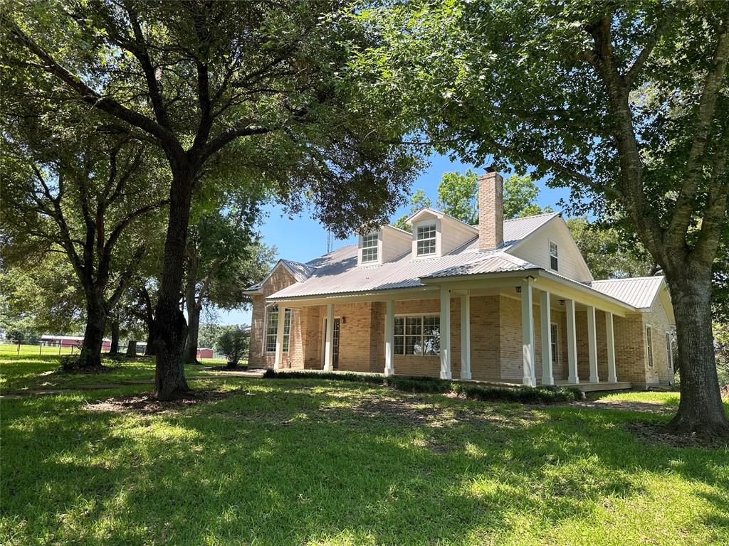 Welcome to amazing hilltop views from both your front and back porches. Picture's do not do this country hilltop home and the 10.5 acres it sits on justice. The home has been nicely updated throughout with new paint, flooring, hardware and exterior upgrades to porches and window. The oversized carport includes workshop space with full bath, kitchenette and washer/dryer connections - the space could be easily converted to living quarters for family or extended stay guests. The home is nestled under the shade of towering LIVE OAKS in the front and back yards. The ACREAGE offers rolling grass covered PASTURES, scattered OAKS with patches of HEAVY WOODS, AG-EXEMPTION in place, multiple HILLTOP VIEWS, PAVED frontage and BEE HIVES. INSIDE the HOME are spacious rooms, open floor plan, hardwood floors, wood burning fireplace, huge master bedroom with shaded back porch overlooking rolling pastures, and upstairs is bonus space great for guest bedrooms/game room/bonus living/office and workout.