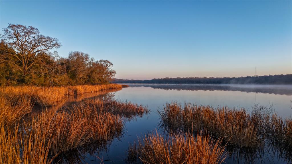 Normangee Lake Ranch offers a rare opportunity to own an extraordinary, one-of-a-kind recreational property that combines natural beauty, unparalleled privacy, and endless potential. Set amidst the rolling hills of Leon County, this 221 acre ranch boasts an 80 acre spring-fed lake, offering exclusive access to world-class waterfowl hunting, bass fishing, & lakefront views. The awe-inspiring scenery, includes towering hardwood, dynamic elevation changes, & incredible wildlife habitat. Whether you're looking for a secluded family retreat, an outdoor lovers haven, or a prime hunting destination, this property offers it all. Enjoy the ultimate blend of recreation, relaxation, and investment potential, all within just 40 minutes of Bryan/College Station. Features include +/- 80 ac. private lake, over 3/4 mile of paved FM frontage, ideal build site locations with incredible lake views, over 70 ft. of elevation change, electric on site, new fencing/gates installed along FM 3, and ag exempt.