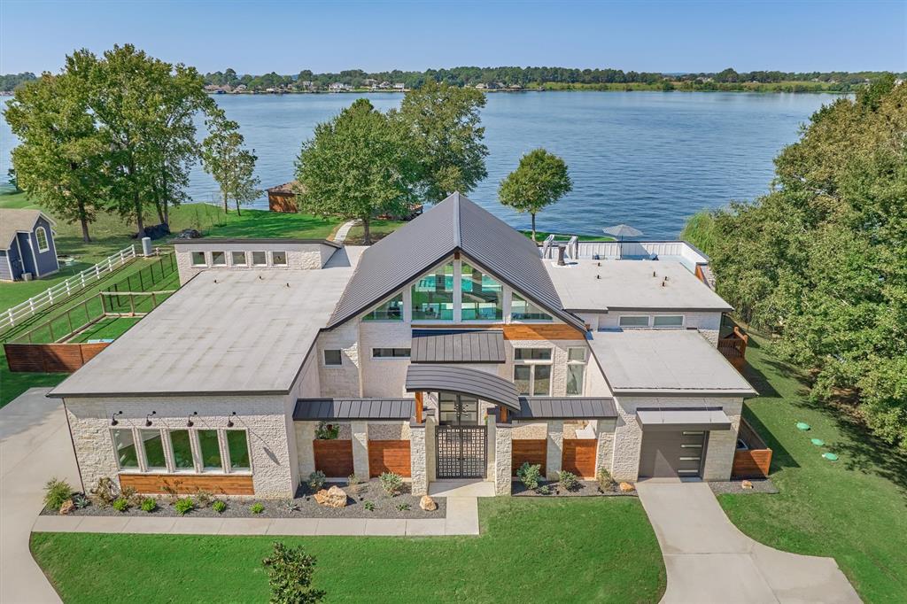 Modern luxury meets lake-style living in this exquisite home on Lake Conroe! This SINGLE STORY home offers 4 bedrooms, 3.5 baths, a game room and 4 car garage. Inside, you are greeted with 30 ft ceilings and expansive windows to maximize the water views. The kitchen was designed w/ Thermador appliances, soft-close cabinets & drawers, under & over cabinet lighting and a quartzite island w/ an abundance of storage. The primary suite offers a 2-person spa, double closets with w/d in each, and peaceful views of the lake! The heated pool and spa were cleverly designed to double as an exercise pool. EV garage chargers, water softener, sprinkler system, dog wash, foam insulation, full house generator and phenomenal boat house w/ 2 boat lifts, 2 jet ski lifts, fish cleaning station and large storage room. Situated on a full, private acre, this property offers the perfect blend of serenity and accessibility, with convenient proximity to hospitals, dining and shopping.