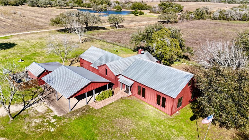 This expansive 4-bedroom, 3-bathroom farm and ranch property offers a generous 3,394 square feet of interior living space, which offers an open kitchen, living, and dining concept. There is an additional wet bar off the living room that leads into a comfortable den. Adjacent to the den are three guest rooms and two bathrooms. Also located here is the staircase which leads you to the upstairs game room, which can be utilized as an additional bedroom. On the opposite side of the house is the large primary bedroom and on suite, complete with it's own designated entrance. Stepping outside, the property unfolds overlooking the 2.5 acre lake complete with mini island, water feature and fishing hut. Deeper into the property you will find woods to explore with abundant wildlife and portions with fields to be cultivated for hay and cattle grazing. 
Prepare to be captivated by the potential and simplicity of life at the Swinging K Ranch.