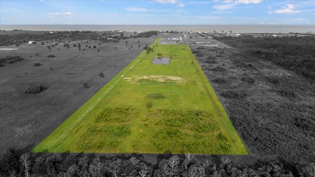 Just across from the bay sits this 12.6 acre tract, with a ranch gate entrance, guiding you to the property that already has a 4,000sf house pad and a pond that reflects the beautiful sunsets off the bay! The perfect back drop for you to start the build of your home! Tucked away, you will enjoy all the nature around! This large spread is convenient to I-10 and central to Houston and Beaumont! Public access to the bay, bayou and lake all within very close proximity! Enjoy nature, while being close to the city when needed!