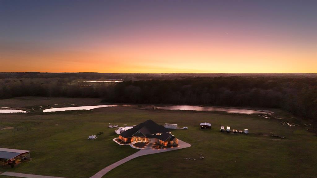 Discover the ultimate equestrian paradise with a 3123 sqft home setting on a sprawling 56-acre horse ranch. Designed for both luxury living and equestrian excellence. The property boasts breathtaking panoramic views, 5-barns, providing ample space for stabling & caring for your horses. The ranch features three spring-fed ponds, fully stocked for fishing & leisurely afternoons, alongside a tank that enhances the picturesque landscape. ElectroBraid fencing surrounds all four pastures, ensuring safety & security for your horses.
Equestrian enthusiasts will appreciate the dedicated riding arena, perfect for training or recreational riding. After a day of outdoor activities, unwind in your private pool complete with a personal lazy river, offering a relaxing retreat. Entertain guests in style with a fully-equipped outdoor kitchen, ideal for hosting gatherings under the stars. This exceptional property seamlessly blends luxury, nature, & equestrian amenities, creating a truly unique home.