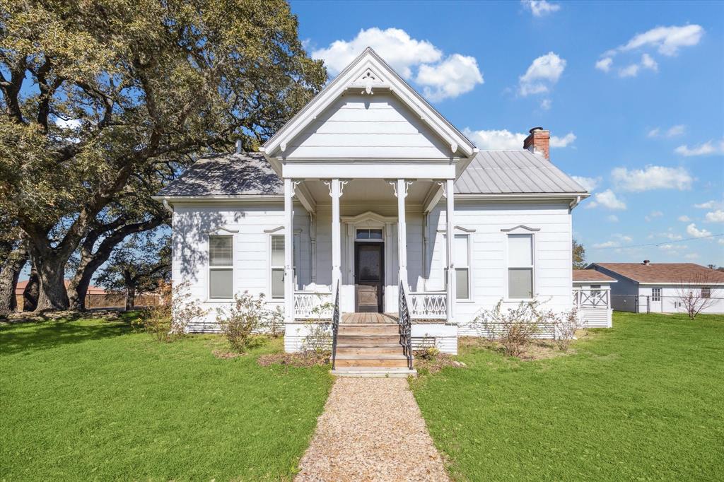 In the charming town of Burton, this captivating 14.65-acre property boasts rolling hills, a serene pond, and picturesque groves of towering Live Oak trees. The circa-1940s home offers timeless charm with 3 bedrooms, 2 baths, formal living and dining rooms, a sunroom, and a kitchen featuring a spacious walk-in pantry. This light filled house has tall ceilings, floor-to-ceiling windows, and original wood floors. A separate building houses the utility room, while a detached 2-car garage includes additional workspace or storage. With approximately 1005 feet of road frontage on FM 1697 and 640 feet on FM 390, this property combines accessibility, natural beauty, and vintage elegance for a perfect retreat or homestead. Ag exemption in place. 90 miles from Houston, 80 miles from Austin and 48 miles from College Station.