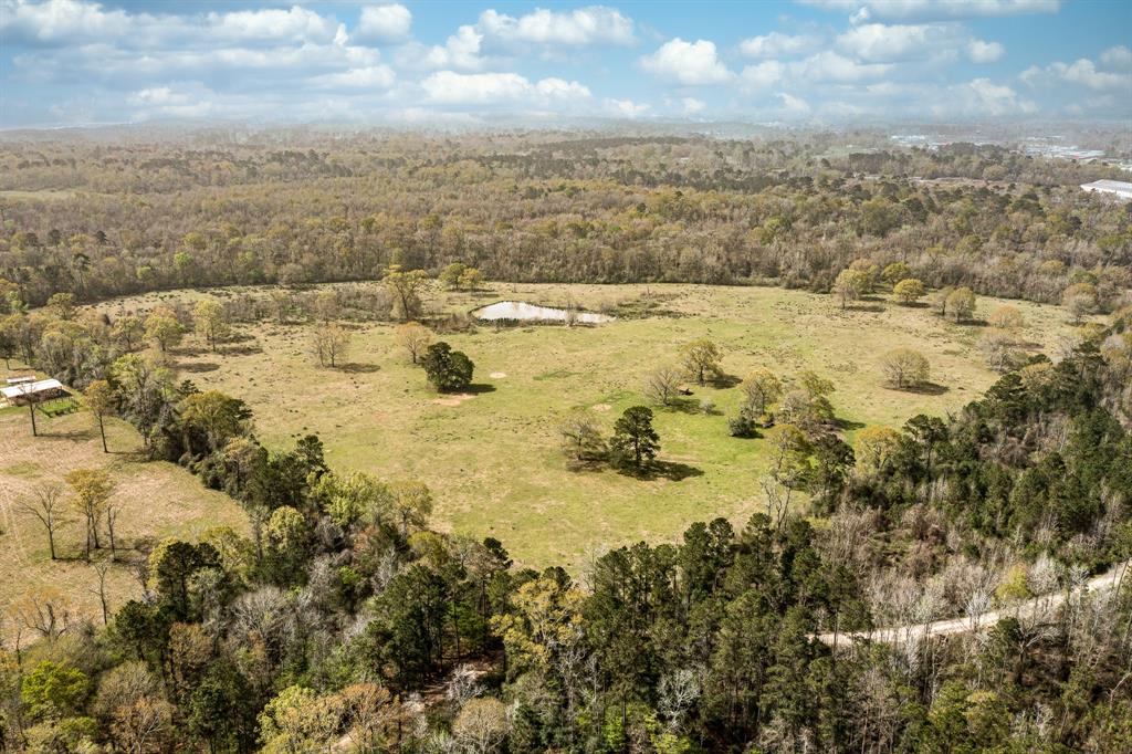 Nestled in a quiet, unrestricted area with convenient access to I-69/Hwy 59 and FM 1010. Looking for a place away from the city to indulge in recreational activities, this 64.27-acre tract is mostly cleared but also includes the wooded area where San Jacinto East Fork River runs at the back of the property. Enjoy this peaceful country setting, surrounded by other large acreage properties. The property does not have CR 332 frontage and is located in the floodway. Buyer responsible for due diligence. A survey is not available. Please refer to the photos for the property dimensions and location.