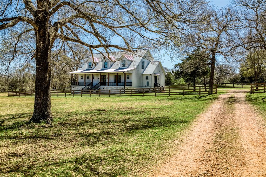 Nestled along the scenic backroads of Austin County, this meticulous and elegant modern farmhouse sits on -/+11 lush acres, offering the perfect blend of luxury and rustic charm. An equestrian dream, the property features a 5-stall barn w/tack room, multiple turnout pastures, and an outdoor lighted arena. The beautifully designed farmhouse boasts open-concept living spaces, a gourmet kitchen with high-end appliances, and a serene primary suite with a spa-like bath overlooking the countryside. A charming guest cottage provides additional accommodations, while a serene pond adds to the property’s tranquility. Several majestic tree types dot the landscape, attracting abundant wildlife. Additional shop/garage with half bathroom and kitchen along with a large chicken coop add to the amenities of a full package property. This private retreat offers breathtaking views, ultimate privacy, and limitless potential. Conveniently located just a few short miles to nearby Bellville. Zoned BISD.