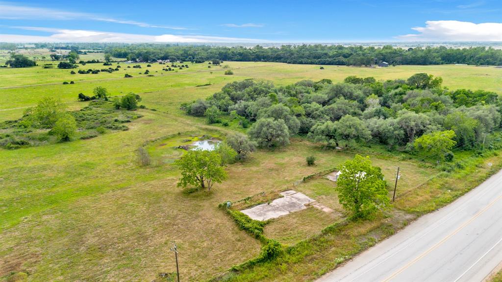 11.56 Acres with electricity, water well, 2200sqft cement foundation, 3-car garage building, gated and fenced with large pond. Directly on Highway 90A about 0.5 mile before Colorado River bridge coming from Eagle Lake city. Ag exempt and unrestricted. Just need to build your home or bring your mobile home.