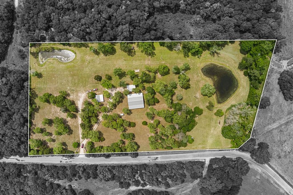 8805 Sun Oil Road Brenham, Texas This 3-bedroom, 2-bathroom custom-built home on 7.4 acres is located less than a 20-minute drive north of Brenham near charming Independence. Perfectly scattered oak trees adorn this property with two ponds and a creek bordering the left and back property lines, offering a serene retreat that is close to modern conveniences. An automatic driveway gate with easy-to-maintain rock landscaping completes the perimeter enclosure that is also cross-fenced with livestock wire. The standing seam metal roof, luxury vinyl plank flooring, and stained wood trim and cabinetry add to the longevity and charm of this farmhouse. The vaulted ceiling highlights the open concept living, dining, and kitchen areas while the split floor plan creates privacy for the master suite. Outside, new owners will enjoy the ample covered front and back porches, a vaulted 22'X30' carport that doubles as a gathering/party space, and a pole barn for storage and additional covered parking space. Schedule your showing today!