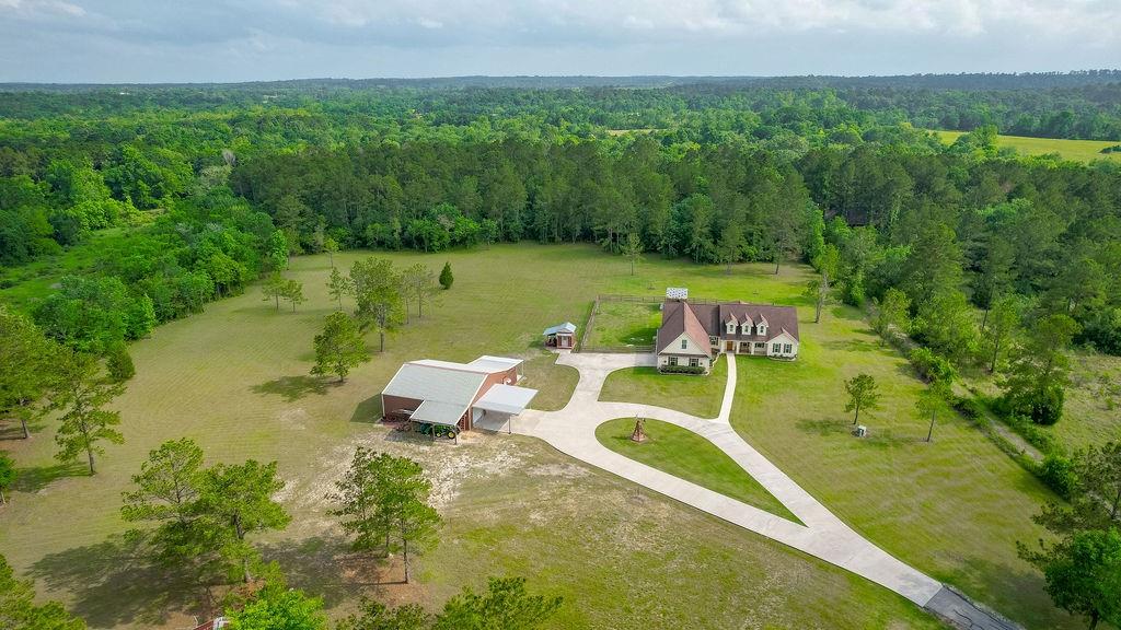 Beautiful Home on 16.5 acres close to Lake Livingston. Front porch has room for a swing. Open concept Living,Dining with a large Island Kitchen and Breakfast Bar. Custom cabinets with special pantry, sliding shelves and special storage compartments. Built-in Entertainment Center holds a large TV., open shelving and additional cabinets.Tray Ceiling,Plantation Shutters. French Doors lead to a large Sunroom with a sink and cabinet, plus a/c. Primary Bedroom has tray ceiling, walk-in closet, en suite bathroom has one as well.Primary bath has a soaking tub, separate shower, double sinks and a dressing vanity, Two additional bedrooms with a hall bathroom between them with 2 vanity sinks. Large bonus utility room has a washer & dryer connections in a closet,sink,and lots of cabinets. Game room up with a half bath above the Over size garage with epoxy floors. Luxury vinyl flooring.Tile in bathrooms. 40X40 Workshop & Man cave with a/c, porch, Carport and two Lean to's, Garden Shed. Gated Entry