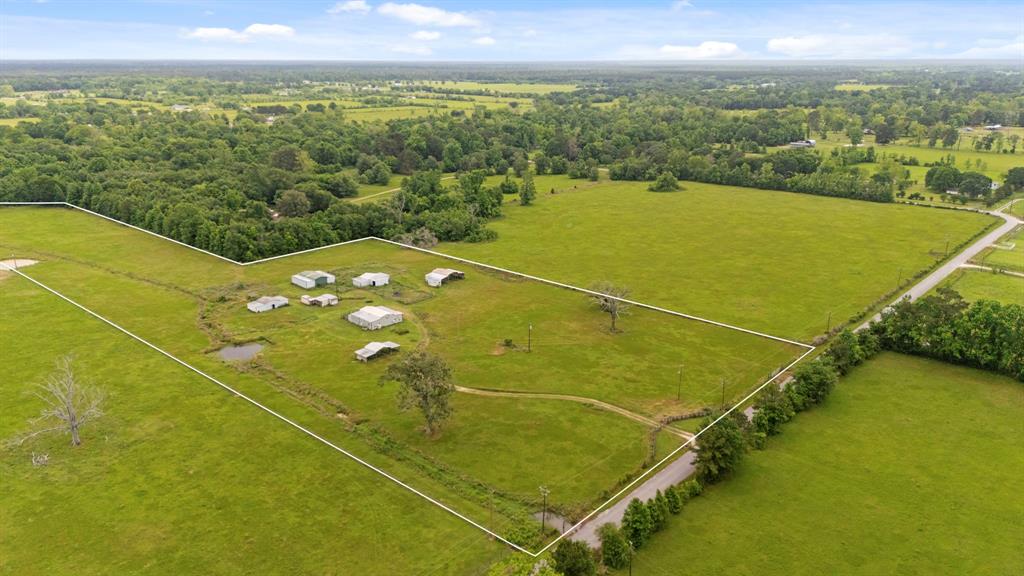 1585 County Road 2066 Hull, Texas Nearly 12 Acres of Private, Peaceful Country Living! Escape to wide-open spaces with this beautiful property, offering nearly 12 acres of fenced land—perfect for animals, farming, or simply enjoying the quiet of the countryside. Multiple outbuildings provide everything you need to start your country dream living, including a hay barn, feed and tack room, a barn with three stalls and additional storage, a workshop with two stalls, and a carport ideal for an RV, boat, or tractor. There's also an established hay field and a barndominium-style living space with a kitchen awaiting your finishing touches—ideal as a guest space, rental, or primary residence. Recent upgrades include new electric in the outbuildings, supporting both functional farming and recreational use. Conveniently located with easy access to Liberty and Dayton, this unique property offers a rare opportunity to embrace true country living with all the space and utility you need.