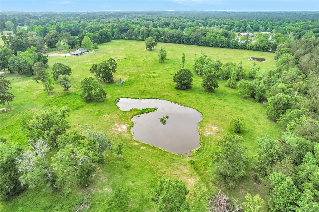16180 Highway 321 Dayton, Texas Escape to your own secluded country paradise on 23+ acres. This expansive estate features 3 ponds, perfect for farm animals or wildlife. Relax by the in-ground pool or explore the 40x60 pole barn for storage. The charming 1-story bungalow offers a peaceful retreat with all-brick construction and low-maintenance siding. Stay organized with a generous carport for 3 cars and a Mule. Don't miss out on this tranquil oasis!