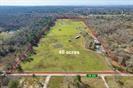 806 County Road 325 Cleveland, Texas A prime real estate opportunity has emerged with the listing of a 40-acre parcel of land for sale. Situated in a rural setting, the property boasts 38 acres designated for agricultural use and 2 acres zones for residential purposes. The agricultural land holds an AG exception, indicating suitability for farming activities. The land is utilized for cattle farming, offering ample space and facilities to support livestock operations. Among its notable features are a cattle ramp for easy loading and unloading. Also has roofed cattle feed areas that are equipped with cement troughs for feeding convenience. The property benefits from the availability of 220v of electricity that extends throughout the middle of the land, particularly around the cattle stables. The property is well equipped to support agricultural activities with five automatic water dispensers placed efficiently for easy water access. Commercial septic tank on property meets standard sanitation needs.