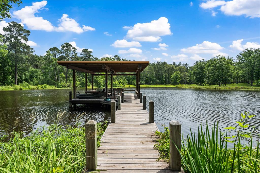 Peaceful, quiet and absolutely stunning 16+ acre property which includes a 3 AC pond stocked with catfish, blue gills and bass! Abundant wildlife, hunting opportunity, and outdoor paradise for your family, friends and fur babies! The view of the pond and property from this home is PRICELESS! Family room and dining room have walls of windows with constant surrounding views! Kitchen features Jenn Air appliances, huge island and ample counter top for prep and cabinets for storage. Walk in pantry. All appliances included. This custom home features 2BR 2BA split floor plan plus office, bonus room behind kitchen and flex room connected to the owner's retreat currently used as workout area. Covered boat house with 2 spots, electric lift and lights. 416 SF detached craft room with built in tables and storage with AC. Covered outdoor kitchen area. Firepit. Goat pen. Storage shed. 24 KW Generator. Deer Stand. City water plus 2 wells on property. Irrigation on pond. Fully fenced and gated.