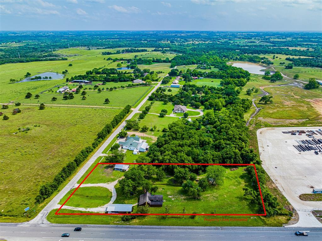 3100 William B Travis Road Brenham, Texas INVESTMENT OPPORTUNITY: UNRESTRICTED Tract on Highway 290 hard corner!! This beautiful ~2.5 Acre Tract with ~470 ft of Highway 290 Road Frontage sits just minutes out of Brenham & Chappell Hill is ready for Commercial Development, Residential use OR BOTH!
The property neighbors the brand-new Corrosion Resistant Alloys (CRA), is across the street from South Texas Tack and is also on a residential street making a wonderful opportunity to live and run your business from the same property OR build a brand-new development.
The land consists of 2.49 acres with scattered trees. On one side of the property sits a 2-Bedroom Log Home with Detached Garage and a Grey Studio Cottage. The other side of the tract is open pasture. Two brand new septic systems (2022 & 2023) and one water well service both homes. There are three entrances to the property. Grey Cottage is leased at $900/month and the Log Home was leased for $1200/month, but is vacant now.Priced for Land value at $4.80 per square foot.