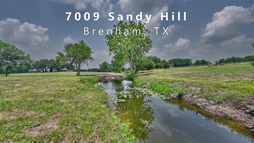 7009 Sandy Hill Road Brenham, Texas Own a Piece of Texas History! – 31.5 Acres which includes the legacy of Sam Houston and a live oak paradise! A Texas Historical Marker commemorates where Sam Houston was baptized in 1854 in the rock bed, clear running waters of Little Rocky Creek shaded by overhanging trees. Towering, enormous live oak trees sprawl across the land, offering generous shade and a serene setting perfect for gatherings with friends and family. Nestled among these majestic trees is a charming 1,225 sq ft home with 2 bedrooms, 1 full bath, and an inviting open-concept layout. Just outside, a covered front porch provides a spot to enjoy quiet mornings or relaxing evenings, surrounded by nature. A spring fed creek meets Little Rocky and winds in a scenic horseshoe around the property parallel to the intersecting roads. Whether you're looking for a private retreat, recreational escape, or agricultural opportunity, this property offers it all. Don't miss this amazing chance to own a historic Texas treasure.