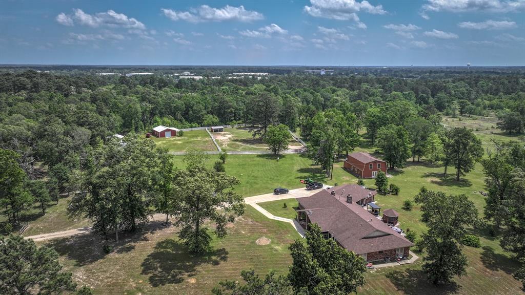 Nestled in the ever popular Montgomery County in Conroe, Texas, this extraordinary ±46-acre property is a rare find that combines the serenity of country living with the convenience of nearby city amenities. Offering a harmonious blend of luxury, functionality, and natural beauty, this estate is a dream come true for those seeking space, privacy, and a connection to the outdoors. Adding to the appeal, this property carries an agricultural exemption, helping to keep property taxes low while supporting various agricultural pursuits. The estate includes multiple well-maintained structures including shops, barns, and storage buildings. Whether you raise livestock, manage land, or simply enjoy outdoor projects, these facilities provide the space and functionality needed to operate efficiently. With its proximity to Conroe, residents can enjoy the best of both worlds—peaceful country living and easy access to shopping, dining, schools, and healthcare. It’s not just a property—it’s a legacy.