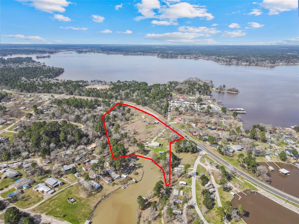 This stunning 9-acre waterfront property offers endless potential with no zoning restrictions. Whether you envision an RV park, vacation rental, marina, or private retreat, this versatile estate is ready for development. The property includes a main home, bunkhouse, independent guest cabin, barn, and storage sheds. Enjoy breathtaking water views from the 450 sq. ft. porch, overlooking your private double boat launch and dock. This property presents an excellent opportunity for expansion, with the potential for up to 75 RV sites. Currently, 10 sites are in place, supported by existing infrastructure, including 10 sewer connections, two 50-amp electrical hookups, and a water connection.
