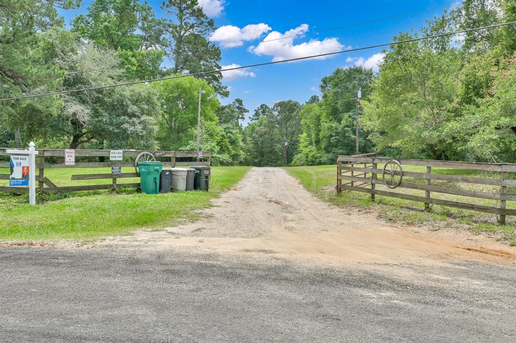 Nestled on 21.9 acres, this property features a 16-acre timber tax exemption. Enjoy the serene 3-acre lake with 2 fishing piers. This prime location 3 miles from downtown Willis has 1000 feet of Rogers Road frontage. The 3 bedroom 2 bath manufactured home has a spacious 20x20 room addition and  an outdoor deck with stunning lake views, all set in a tranquil wooded area. Additionally, a charming guest house sits on the opposite side of the lake, providing a perfect retreat for visitors.