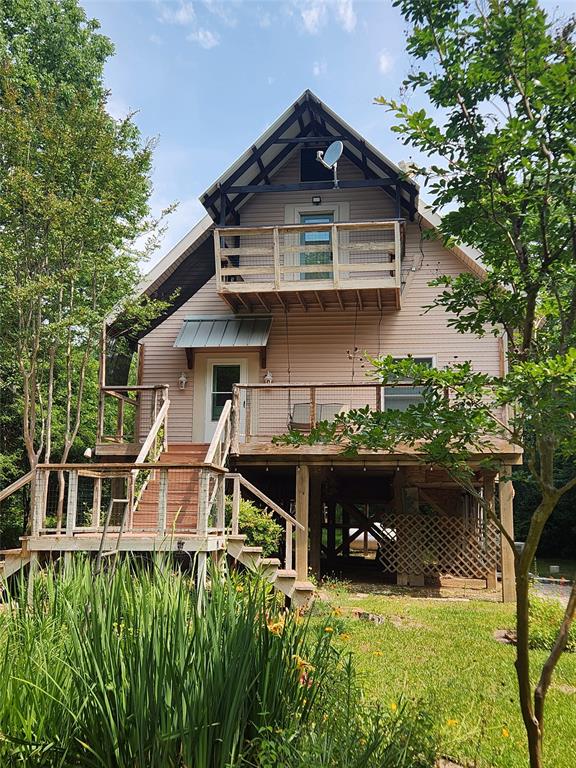 If you are looking for a unique home on acreage with privacy you will find this little gem, reminiscent of a tree house, tucked away just outside Montgomery city limits. The kitchen/living room area makes for a nice open and inviting space. On the main level is the primary bed and bath which offers an oversized soaking tub/shower combo. Upstairs you will find the two secondary bedrooms and a bathroom with a footed tub.  Constructed with 2x6 exterior walls and insulated windows, efficient utility bills are realized.  Approximately 3 acres are fenced, along with a fenced area for livestock and a dog run.  Multiple viewing decks overlook the nature scaped yard. Beautiful natural garden specimens have been incorporated into the landscaping. You will also find lovely walking trails.  The 2 car detached garage has a workshop to the rear of it, and nearby you will find a rustic outdoor shower and small equipment barn. The circular drive and extra parking provide ease of maneuvering vehicles.
