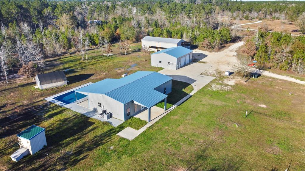 Enjoy the country life! Ride your dirt bikes & ATVs, fish in your stocked pond, swim in your pool, work on your equipment in the shop, shoot guns, raise animals; you can do it all! The main home is 1650 sq.ft., constructed of metal exterior and roof, has spray foam insulation, 3 beds, 2 baths, and an open concept. It's a cozy home with custom cabinets, room for a large dining table, and plenty of room for a huge sectional in the living room. You also have the 400 sq. ft. building with A/C & heat that was used as a guest space. The large shop has room for vehicles and tractors, loft storage, and a 300 sq. ft. laundry/storage room with a 1/2 bath. There is a huge covered RV area with full hookups, an outdoor living space with log fireplace, hot tub, and it's own office that has A/C and good storage.   The property is fenced with a driveway gate, has irrigation throughout, and room to roam.