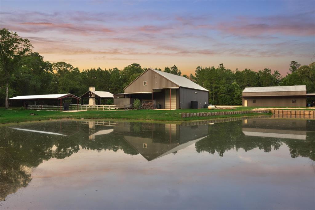 Enjoy serene, private living on nearly 40 acres with this exceptional barndominium-style home in Montgomery, Texas! Designed for comfort and function, this unique property features a beautifully finished home, 40x60 workshop w/ lean-to, sparkling pool & spa, pond, batting cage, and full-home generator. Nestled on approx. one manicured acre, the home offers 3 bedrooms, 4 full baths, a game room, media room, loft, home gym and security system. Enjoy outdoor living with a sunken lounge, outdoor kitchen, and fireplace. The remaining 38 acres of untouched hardwoods provide a wildlife exemption w/ incredible privacy, room for recreation, or future development. A rare combination of tranquility, space, and modern amenities!