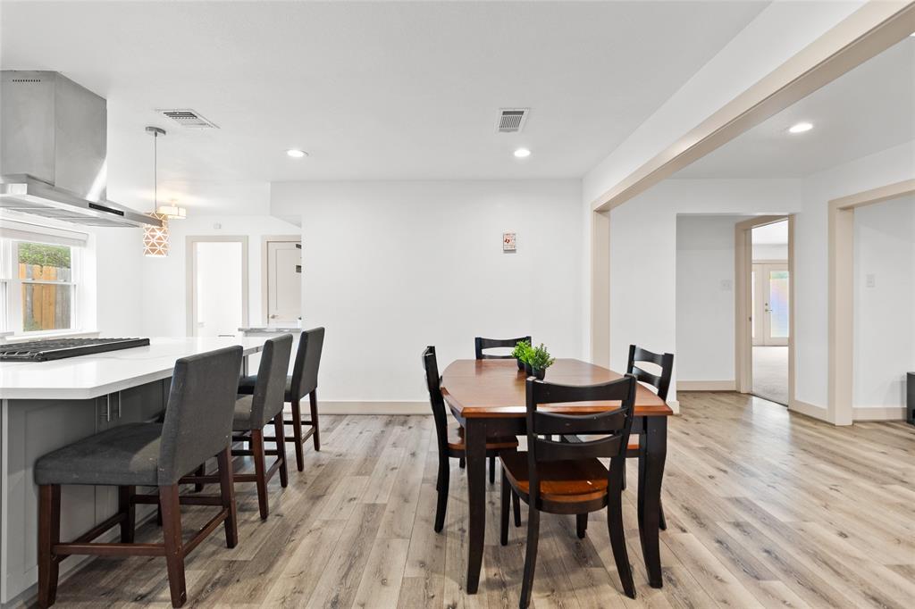 Take a look at your open floor plan seamlessly combining the kitchen and dining areas, perfect for both daily living and entertaining. Wide plank flooring runs throughout, adding warmth and flow, while recessed lighting and large windows keep the atmosphere airy and modern. The expansive breakfast bar offers extra seating and prep space.