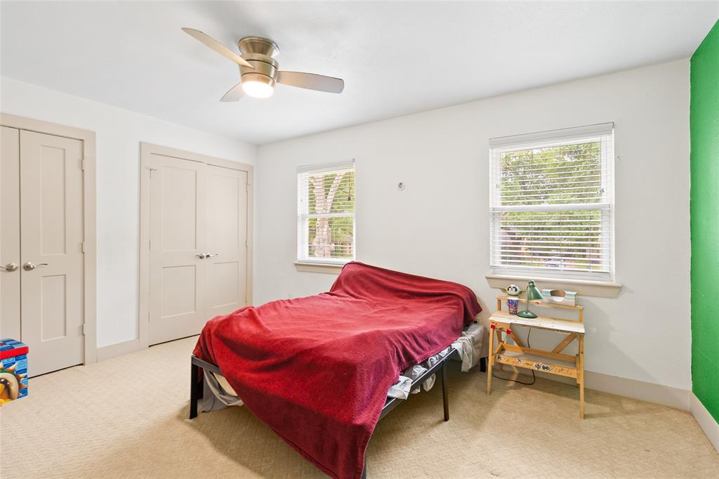 Your first secondary bedroom offers versatility for a variety of uses, whether as a guest room, kids' space, or home office. Dual windows fill the room with natural light, while neutral carpeting and two closets provide ample storage. A ceiling fan adds modern comfort to this bright, adaptable space, ready to suit your needs.