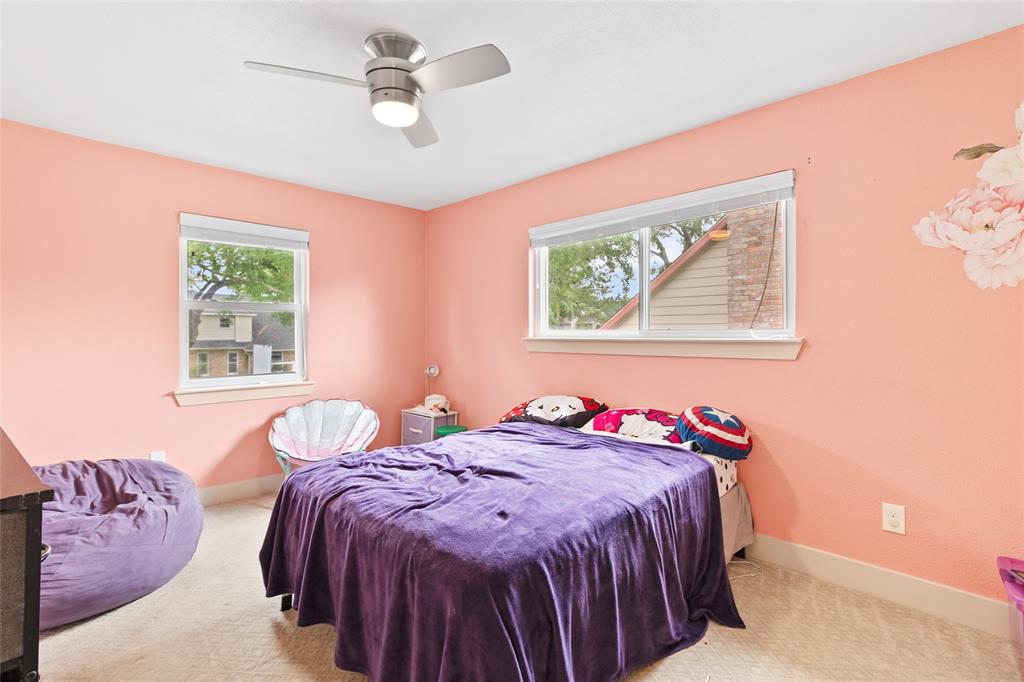 Your secondary upstairs bedroom radiates charm with warm-toned walls and cozy carpet flooring. Dual windows flood the room with natural light, while a sleek ceiling fan ensures year-round comfort. Whether used as a bedroom, playroom, or creative space, it’s a bright, inviting spot ready for your personal touch.