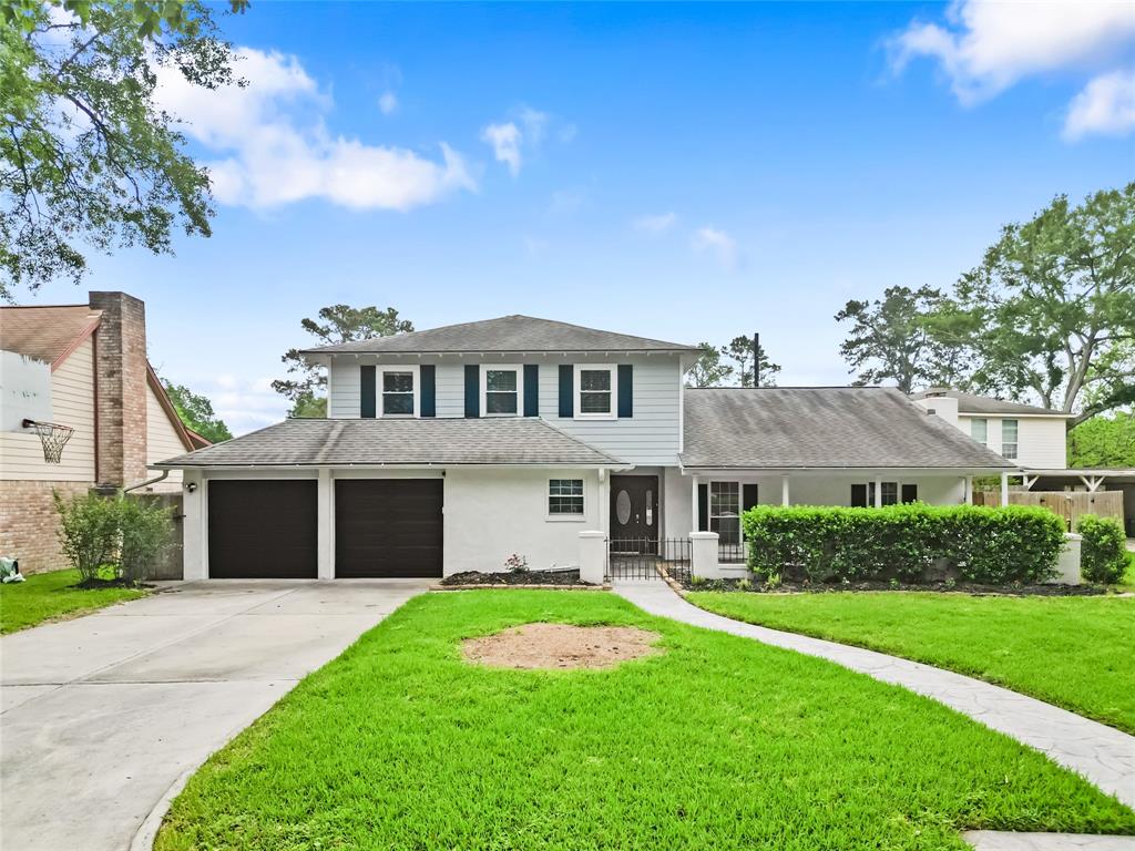 Taking one final look at the front of your home, you’ll appreciate the pristine exterior, lush landscaping, and inviting front porch—perfect for relaxing. A curved pathway leads to the entrance, framed by a gated entry and manicured hedges for privacy. The spacious driveway and dual garage offer ample parking, while the home’s timeless appeal shines through classic shutters and a welcoming facade.