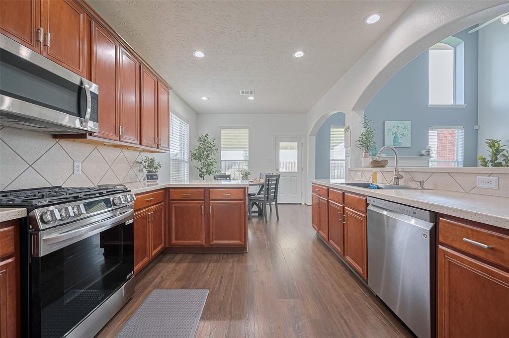 Enjoy cooking in a spacious kitchen with rich wood cabinetry, stainless steel appliances, and ample countertop space.