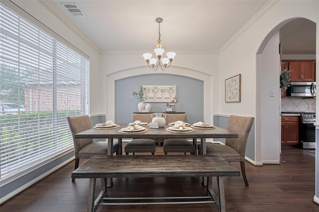 Enjoy meals and memories in this spacious dining room, perfectly suited for a 6-seat table  Natural light fills the space through nearby windows, while the open layout allows easy access to the kitchen and living room—ideal for entertaining or casual family dinners. Elegant flooring and neutral tones create a warm, welcoming atmosphere.