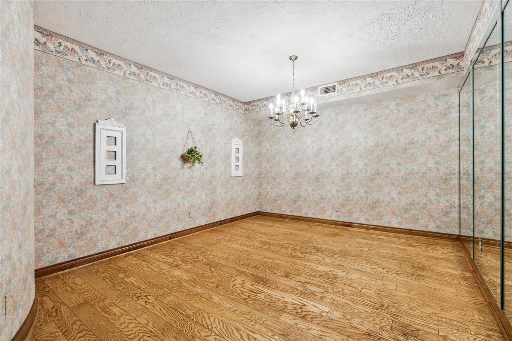 Formal dining with the custom wallpaper and royal style mirrored wall.12190 Willowridge Cir