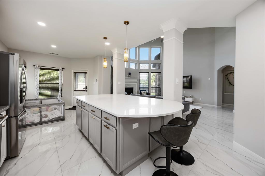 Large custom built jumbo slab white sparkle Silestone island that seats 7 comfortably.
