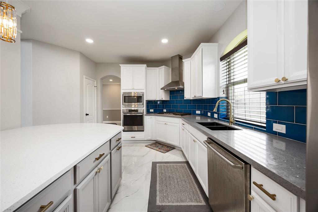 Hood vent, beautiful back splash and high sparkle density gray counter tops.