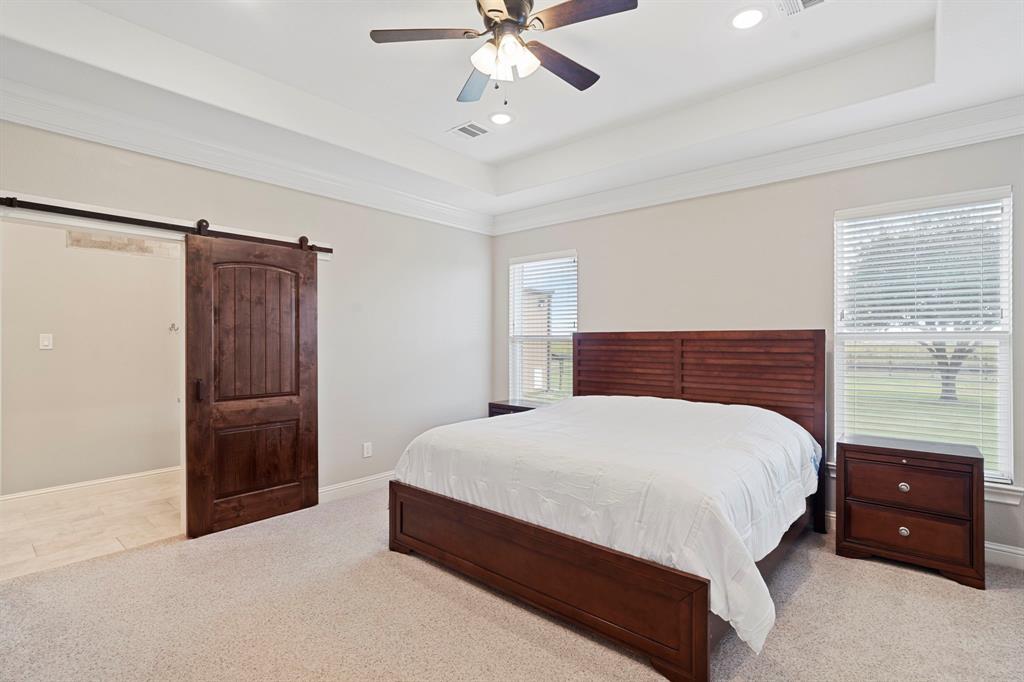 The tranquil primary suite featuring high tray ceilings and plush carpet will be your escape at the end of a busy day. Ample room for large scale furniture and a sitting area. Walls of windows allow natural light to stream into this beautiful space.