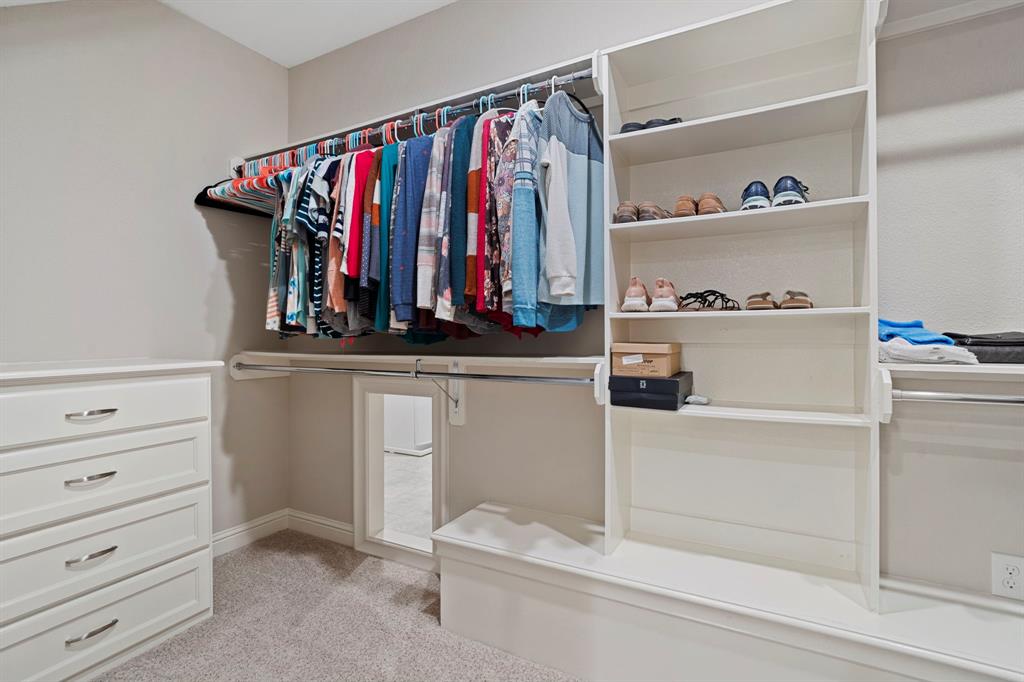 Massive custom closet with built in cabinetry is one of two closets in the primary suite. Ample room to accommodate all your wardrobe needs.