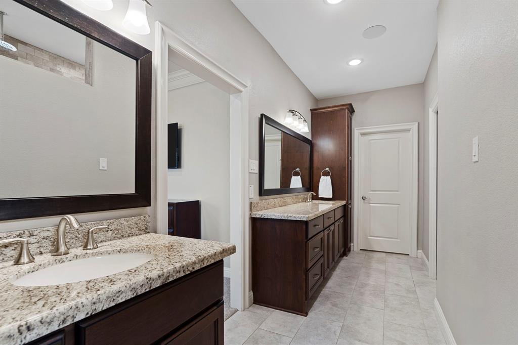 Lavish primary bath boasts abundant counter granite and cabinets. No detail was spared in the design of this exquisite bath.