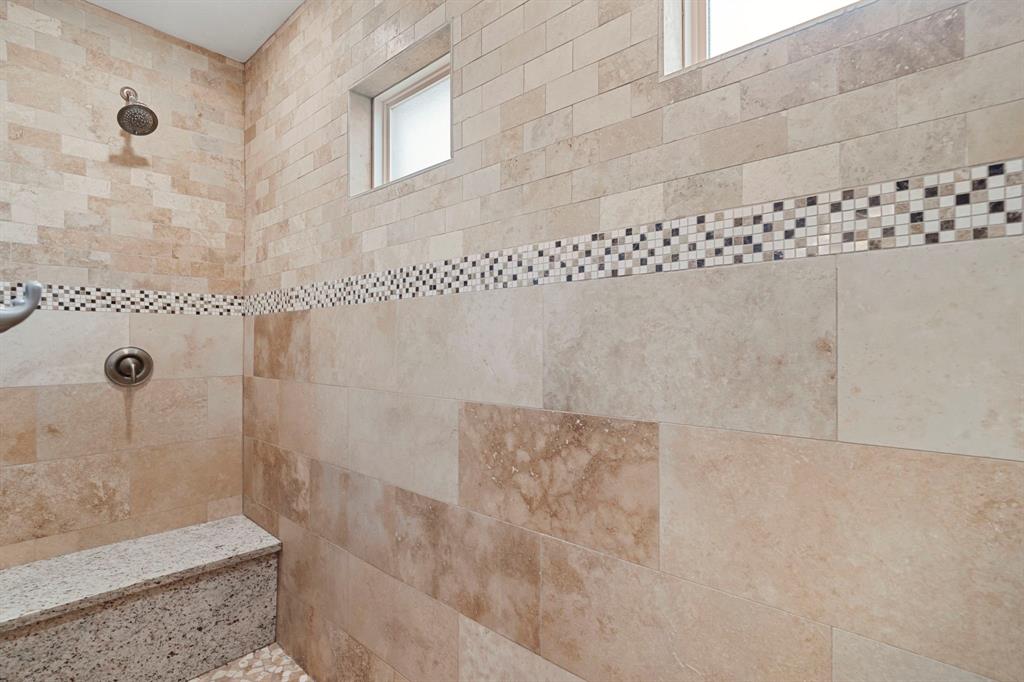 Step into luxury in this super sized shower boasting dual shower heads and bench seating.