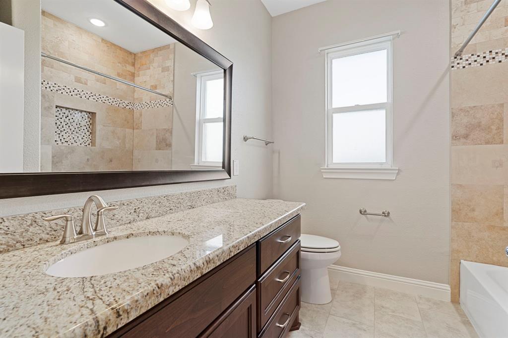 The second of two and one half baths features a large tub/shower. Note the gleaming granite, tile floors and tile surround.