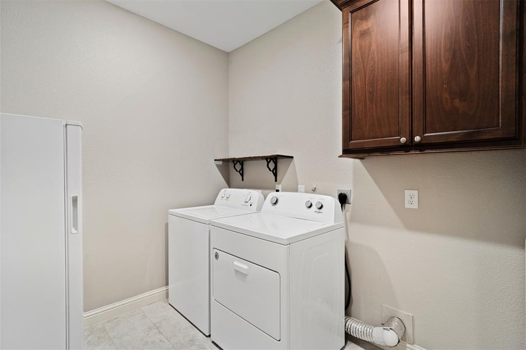 Spacious laundry room with built in cabinetry. Ample room for a refrigerator or freezer.
