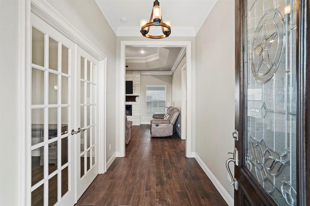 As you enter, the impressive foyer reveals the wood look tile floors and soaring ceilings featured throughout the home. The entry sets the stunning, light and airy tone for the entire home. Every surface from the floors to the ceilings is pure elegance.