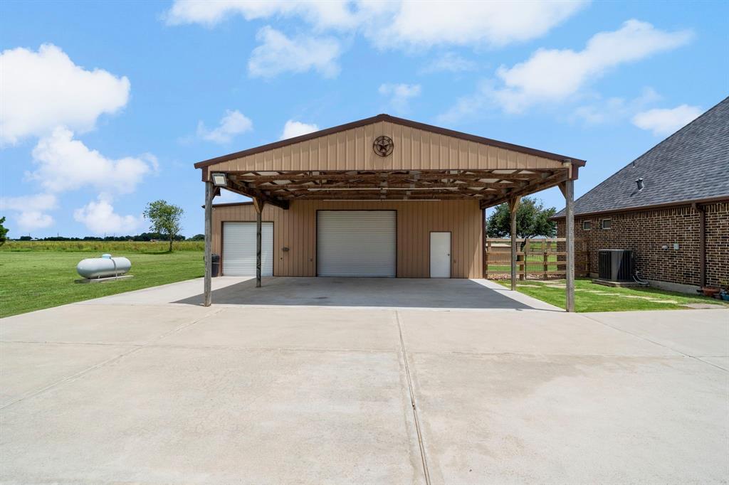 Over sized two car attached garage with workshop. The 1600 sqft. Barn with front and back roll up doors features a kitchen and provides additional 6 car garage parking. The barn could easily be converted to a guest house or stables. 1200 sqft. of covered parking allows extra entertaining space and room for kids to play.