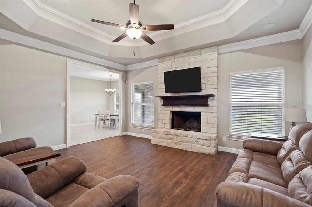 Enter into this stunning living room where the atmosphere is elevated by soaring tray ceilings, creating a spacious and airy retreat. Large windows allow natural light to stream into this great space.