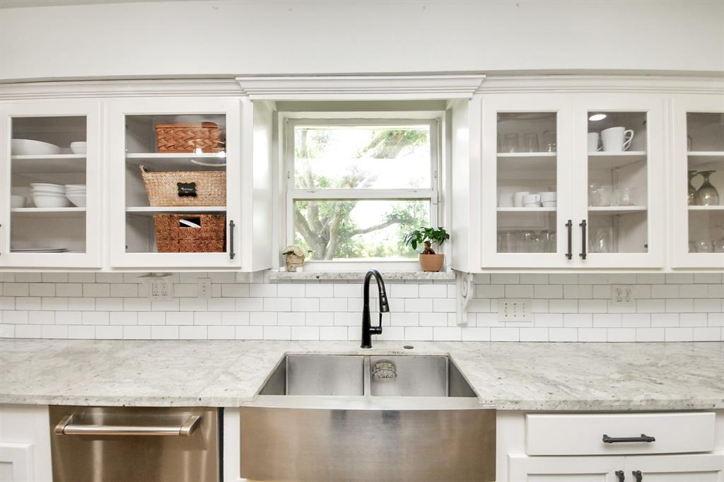 Deep double farmhouse sink set beneath a bright window—offering classic style, modern function, and a serene view while you wash up.