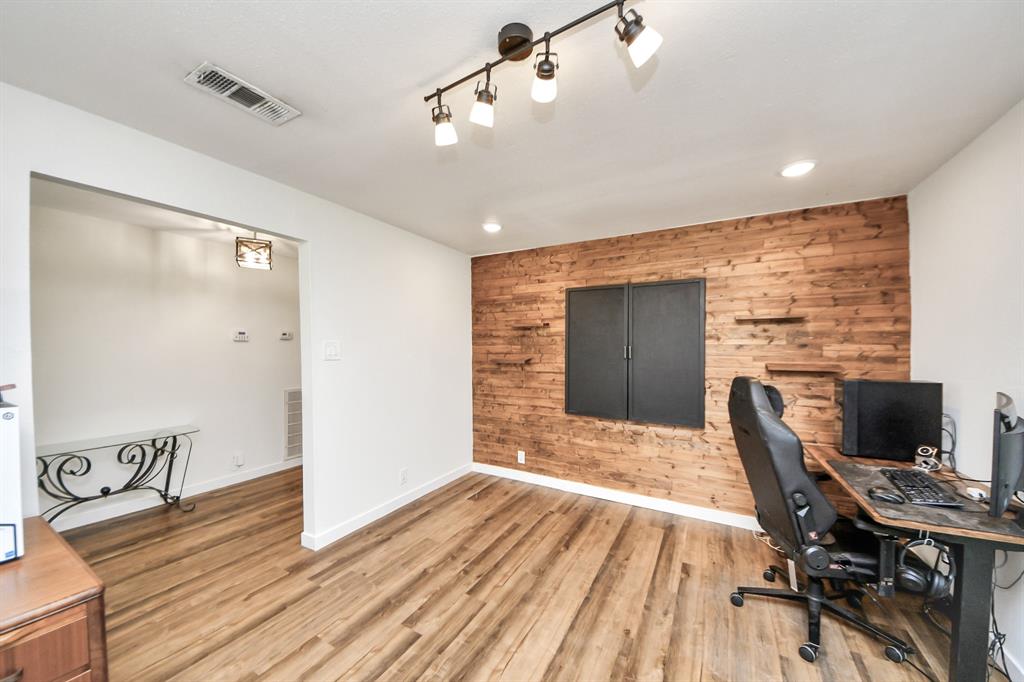 Formal living area or ideal home office, highlighted by a warm wood accent wall that adds character and charm.