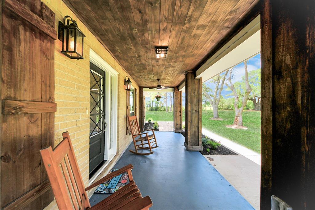 The updated front porch features wide wood posts and a charming ceiling—perfect for morning coffee while watching deer graze under the oaks.